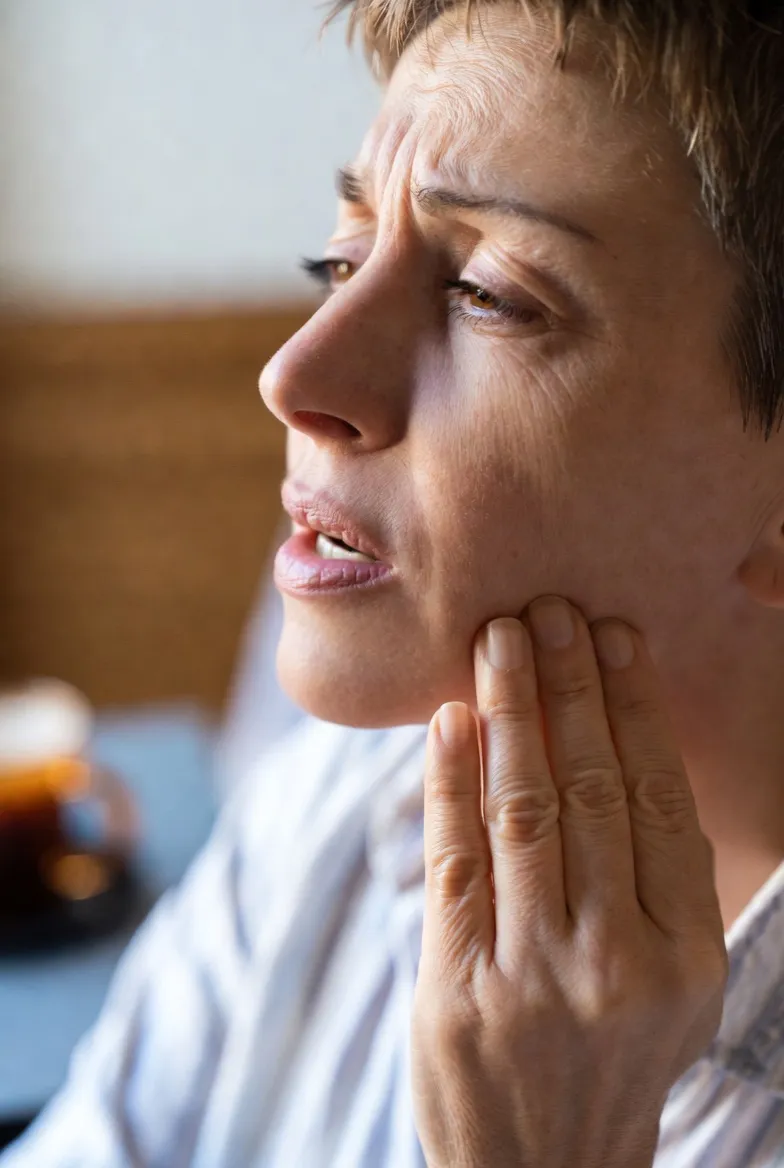 Person experiencing tooth pain holding their jaw